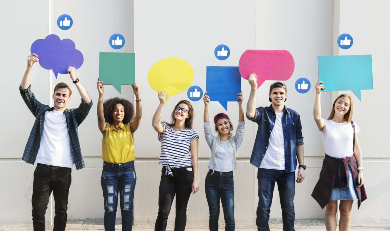 Young adults holding colorful speech bubbles