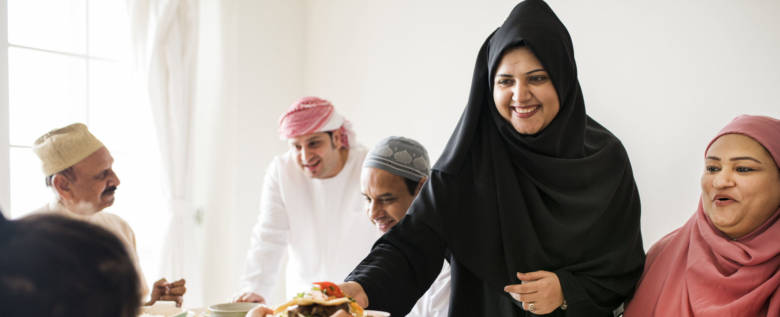Muslim woman sharing food at Ramadan feast